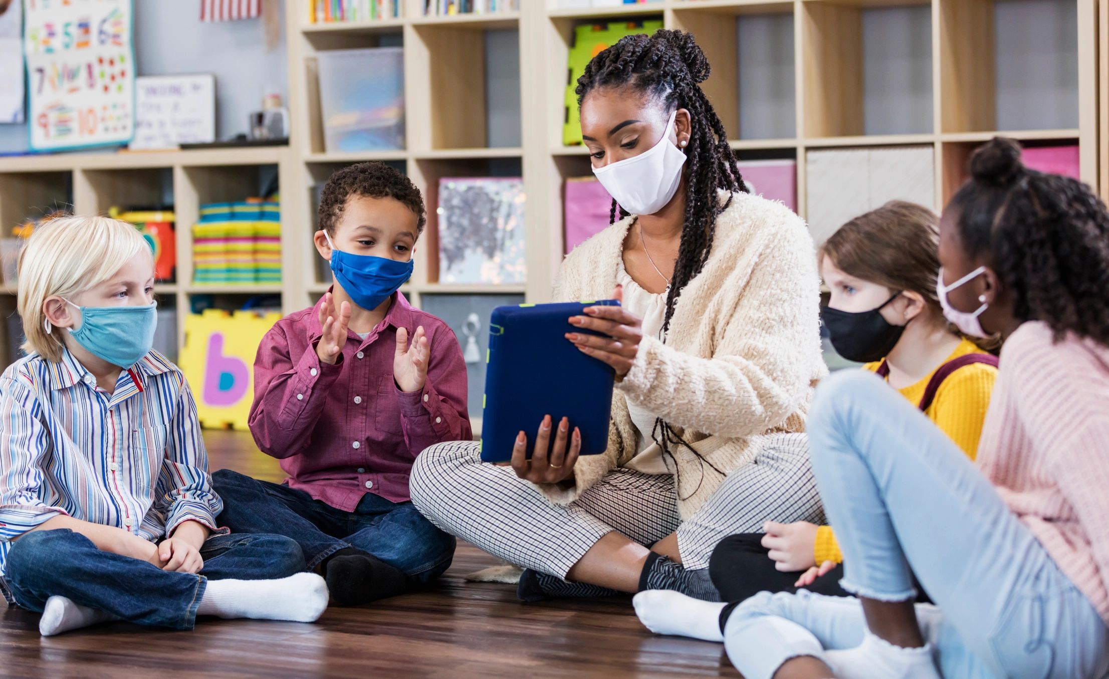 Teacher and children sitting together in a classroom circle