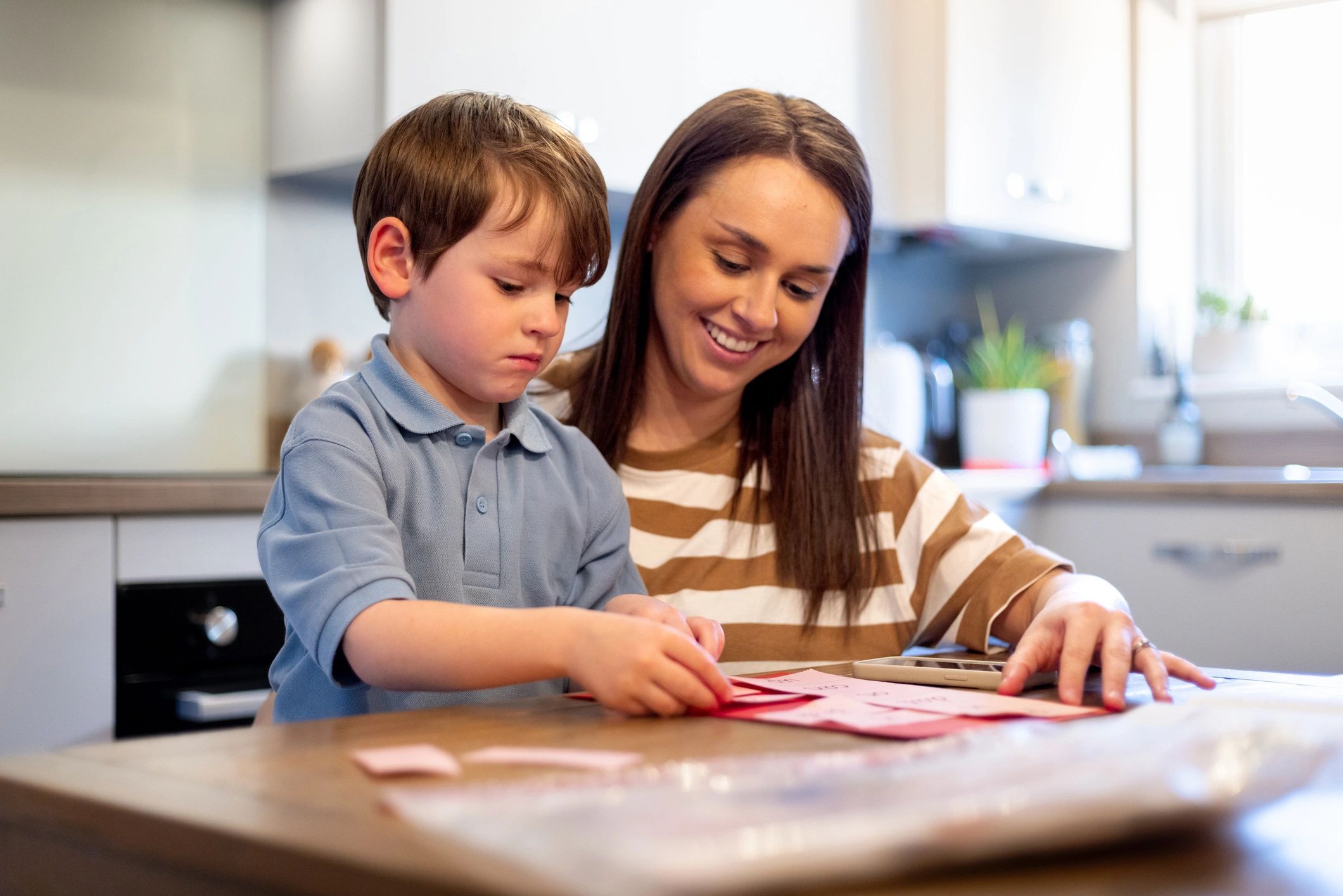 Adult helping a child learn with letters and activities