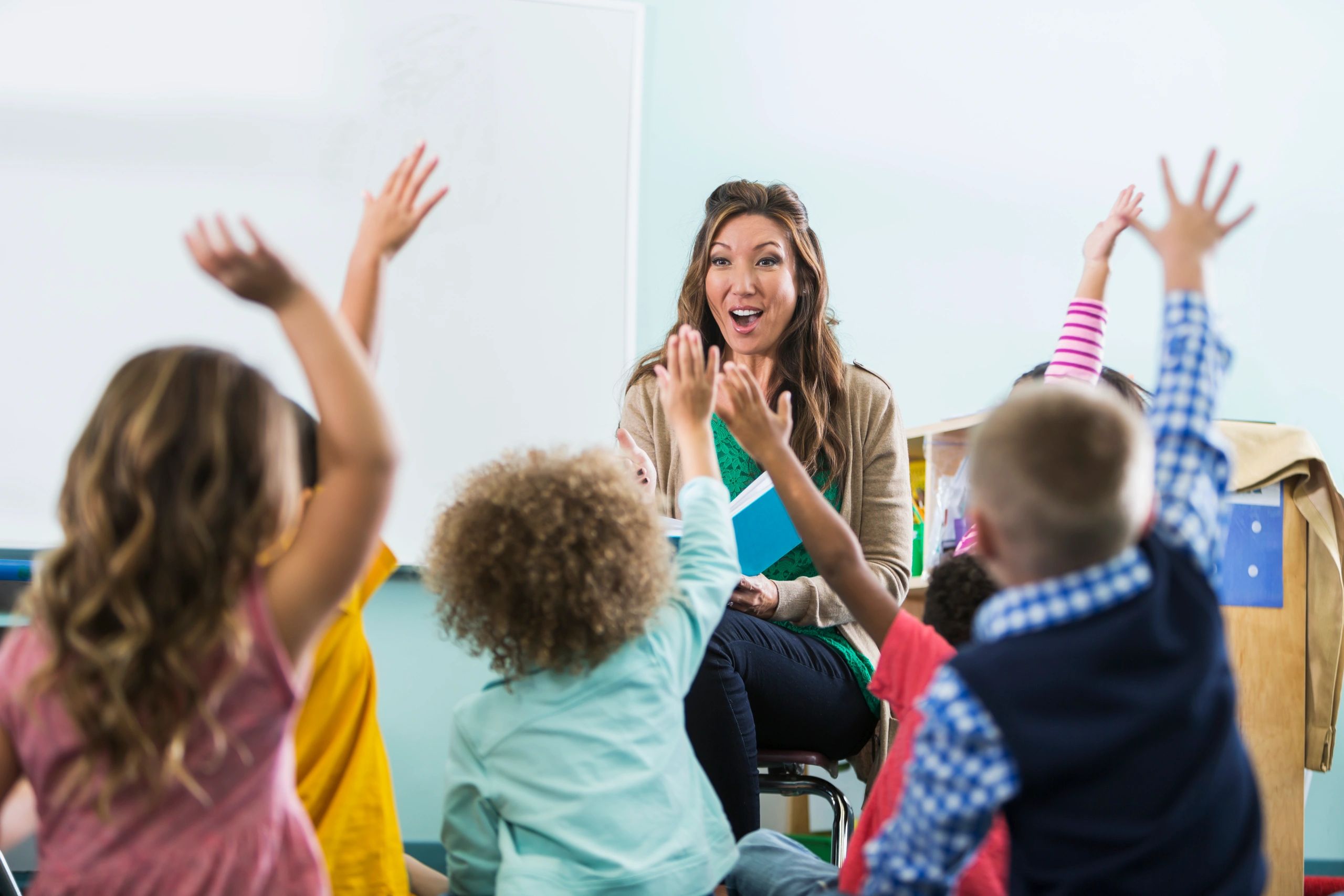 Teacher reading with children in a bright classroom